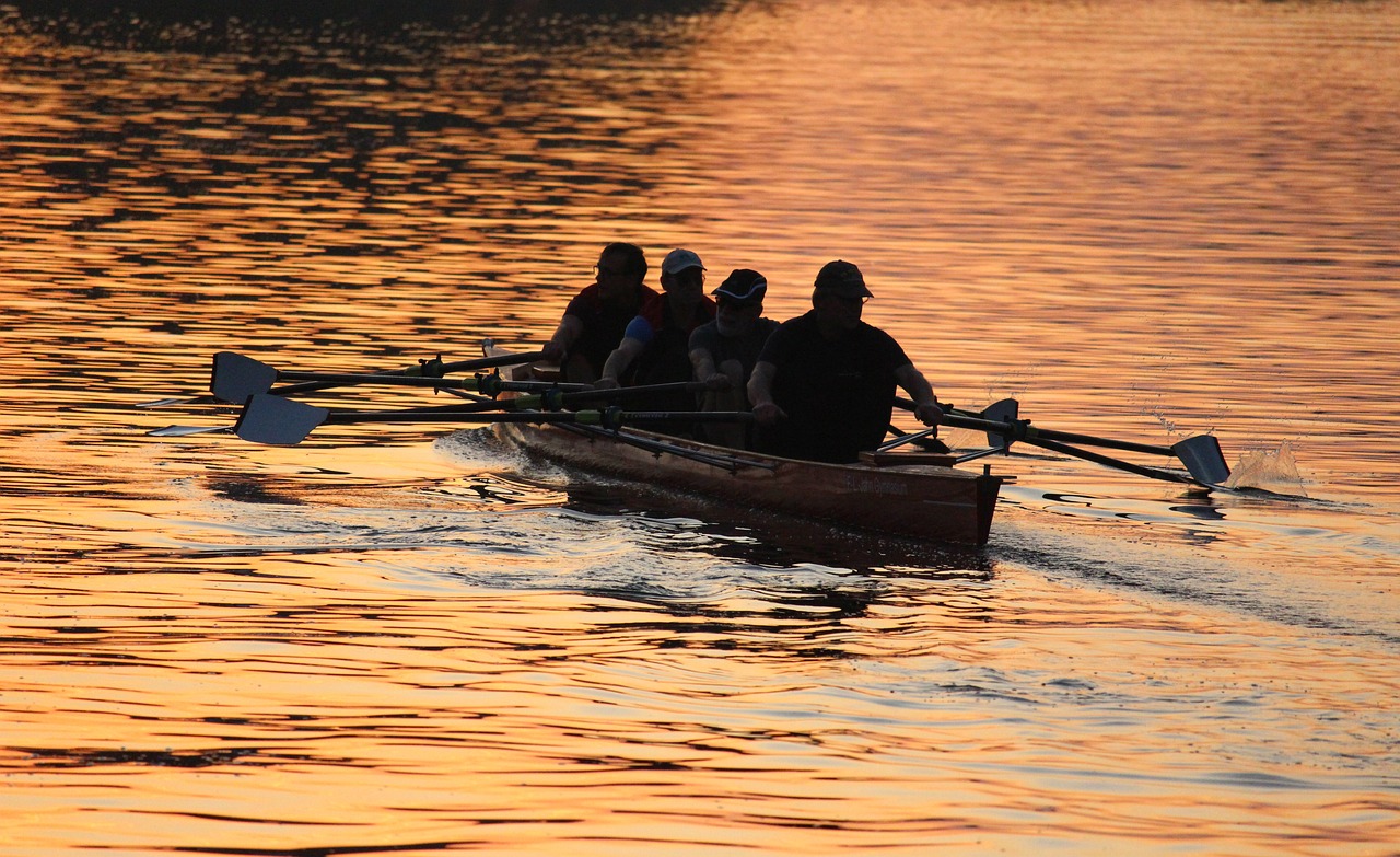 a group of people riding on the back of a boat, flickr, golden glow, rowing boat, “ golden chalice, by greg rutkowski