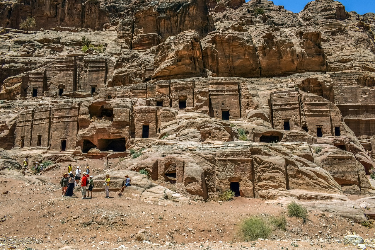 a group of people standing in front of a mountain, a cave painting, pexels, plein air, panorama of crooked ancient city, jordan, stacked houses, usa-sep 20