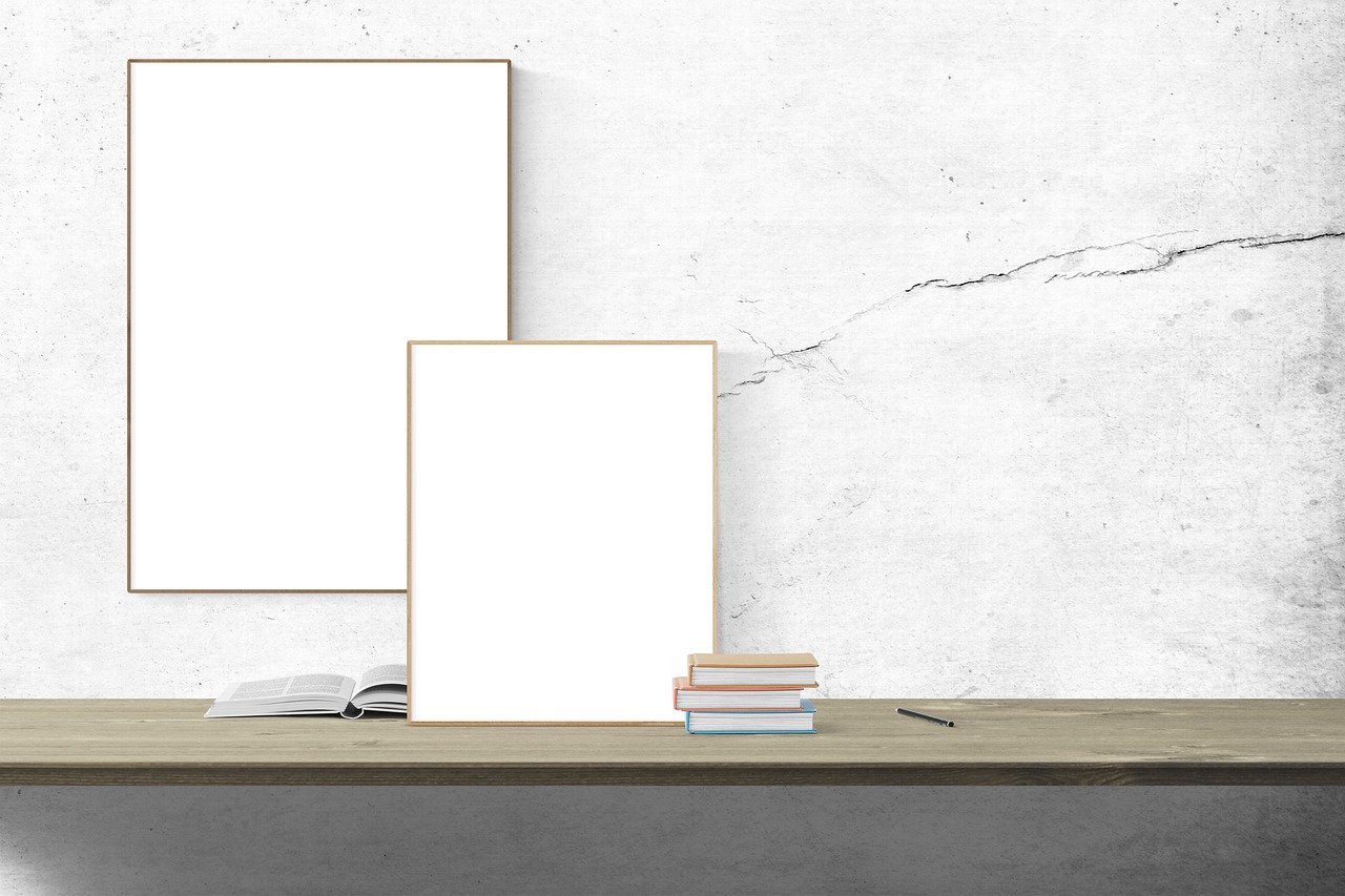 a picture frame sitting on top of a table next to a pile of books, a picture, by Jan Kupecký, shutterstock, visual art, white concrete floor, whiteboard, stone marble, stock photo