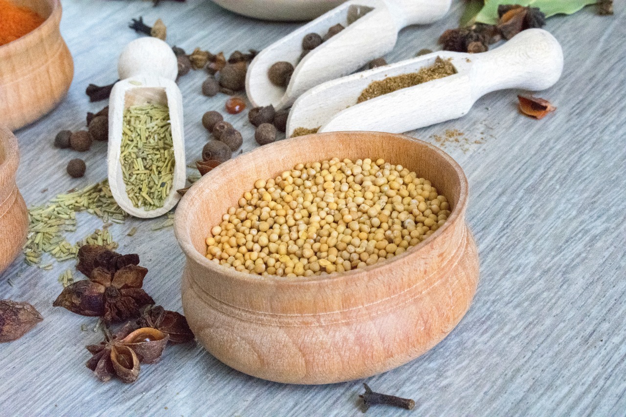 a wooden bowl filled with seeds and spices, dau-al-set, close-up product photo, mustard, ingredients on the table, 💣 💥💣 💥