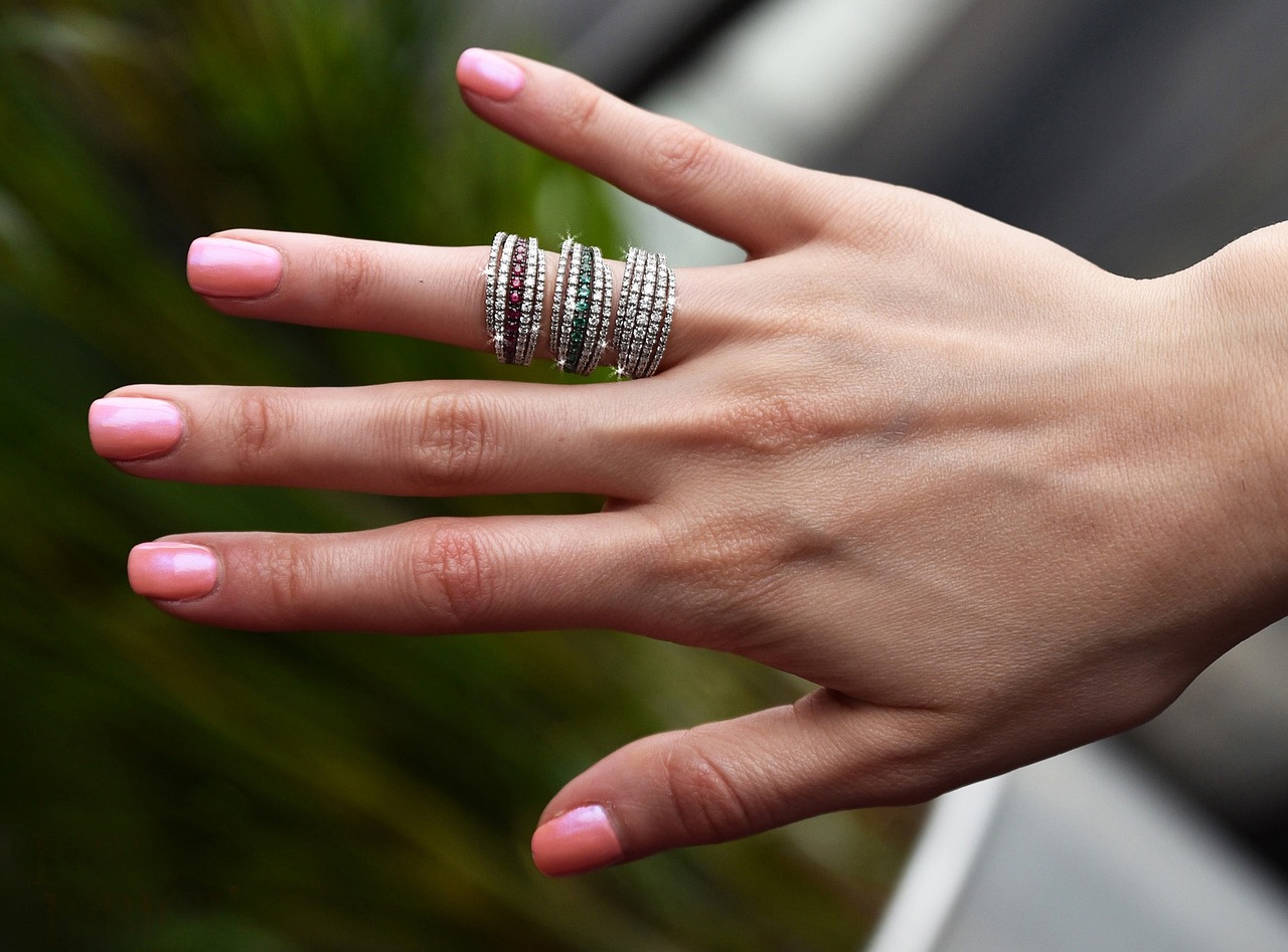 a close up of a person's hand with a ring on it, a picture, shutterstock, huge spines, grey and silver, wearing jewellery, spiral