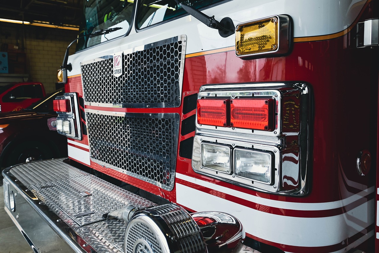 a red and white fire truck parked in a garage, by Adam Rex, pexels, photorealism, cinematic closeup!!, neck zoomed in, dramatic lighting !n-9, file photo