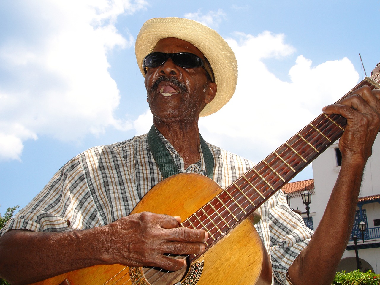 a man with a hat and sunglasses holding a guitar, flickr, jamaican, an 80 year old man, square, on a sunny day