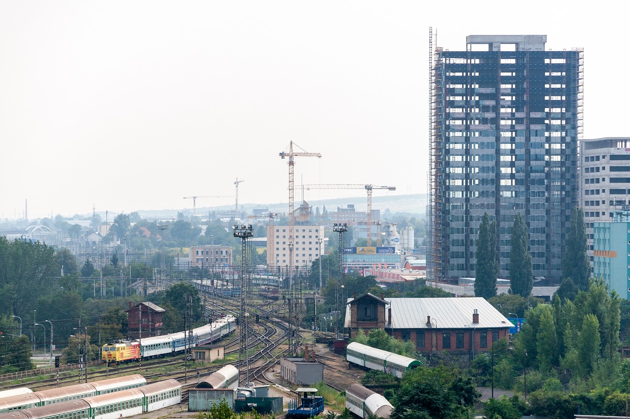 a train traveling down train tracks next to tall buildings, a portrait, bauhaus, ukraine. professional photo, under construction, morning haze, img _ 9 7 5. raw