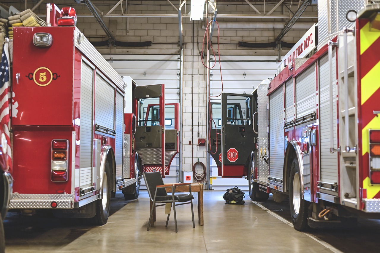a group of fire trucks parked inside of a building, process art, commercial photography, sitting down, banner, full room view