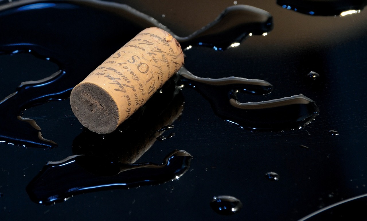 a cork of wine sitting on top of a black table, by Emanuel Schongut, pixabay, conceptual art, black paint drops, crack pipe, wet clay, masterpiece on a scroll