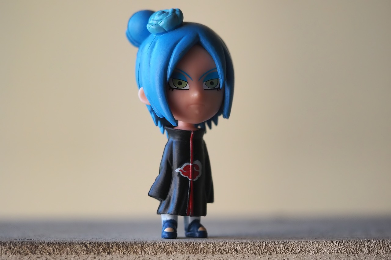 a close up of a figurine of a person with blue hair, inspired by INO, flickr, wearing black clothes and cape, chibi girl, full shot photo, with serious face expression