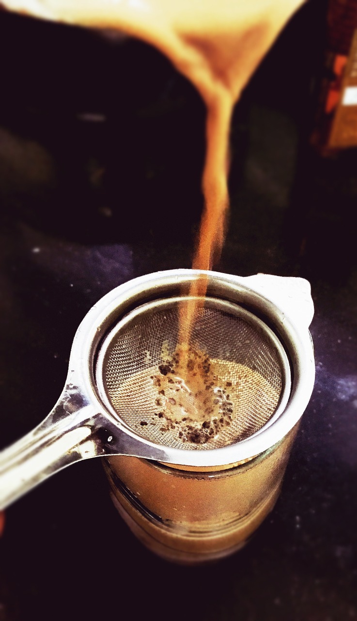 a metal strainer filled with liquid sitting on top of a counter, by Romain brook, flickr, cappuccino, blending, make it spicey, tea