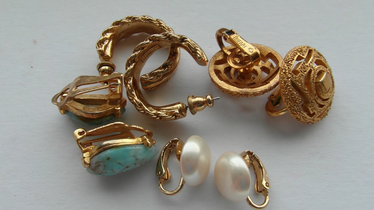 a bunch of jewelry sitting on top of a table, by Anne Savage, baroque, golden earrings, cyan, tan, egg