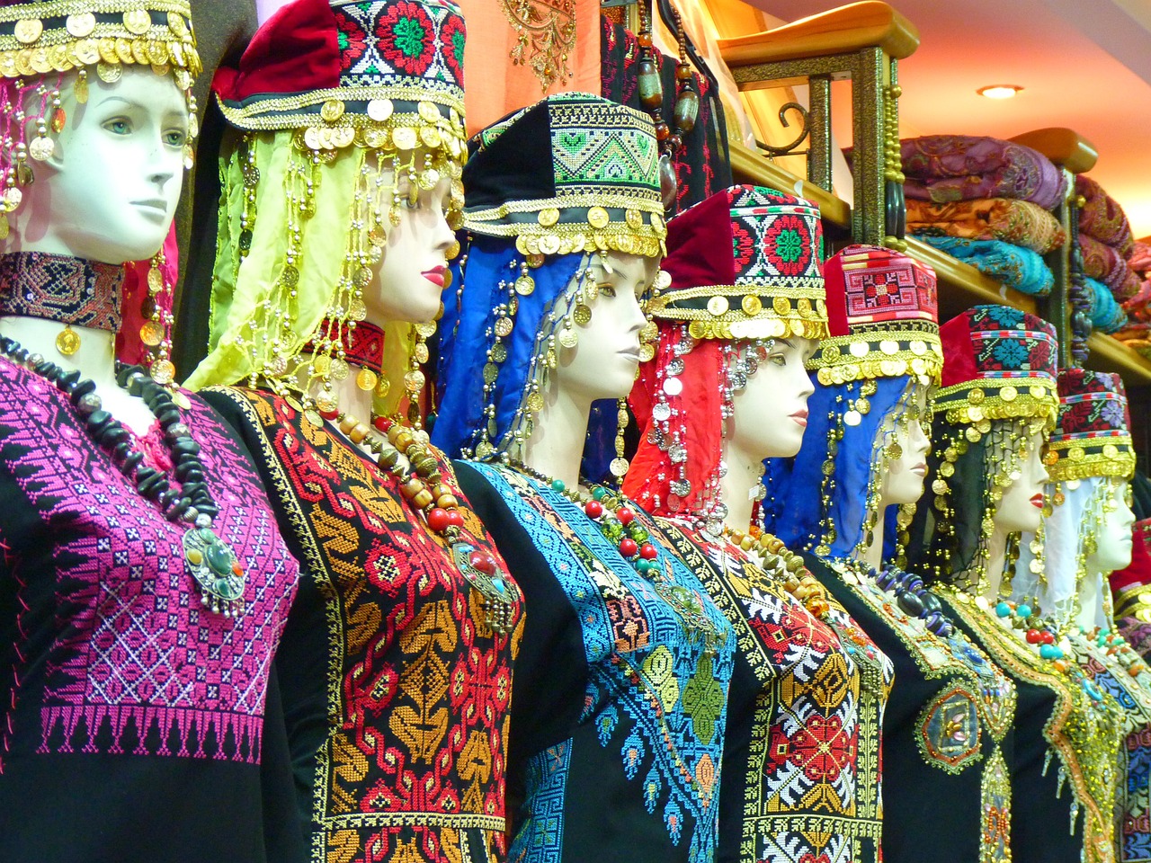 a group of mannequins standing next to each other, egyptian art, by Susan Heidi, shutterstock, qajar art, jeweled headdress, inside an arabian market bazaar, kurdistan, wearing beautiful clothes