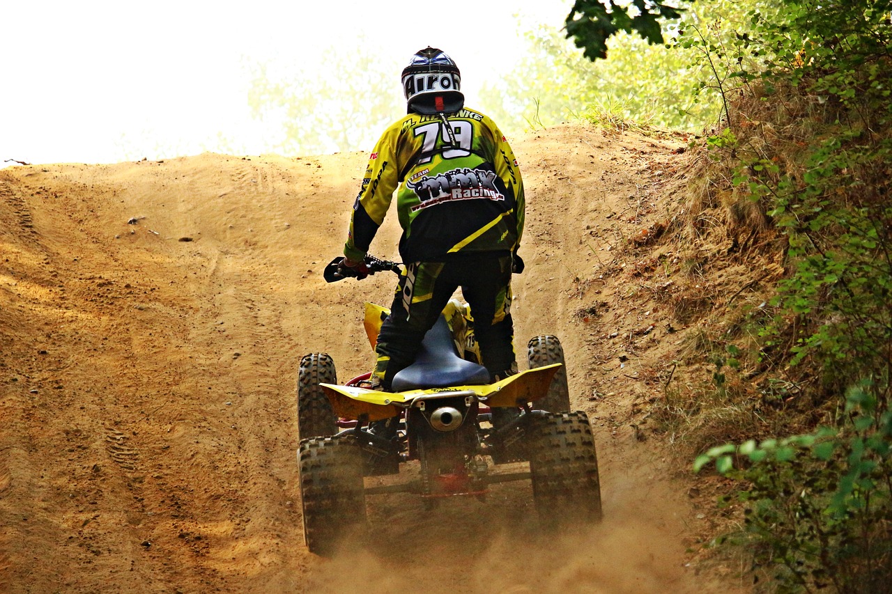 a man riding a four wheeler on a dirt road, a photo, flickr, figuration libre, massive vertical grand prix race, yellow, jovana rikalo, grind