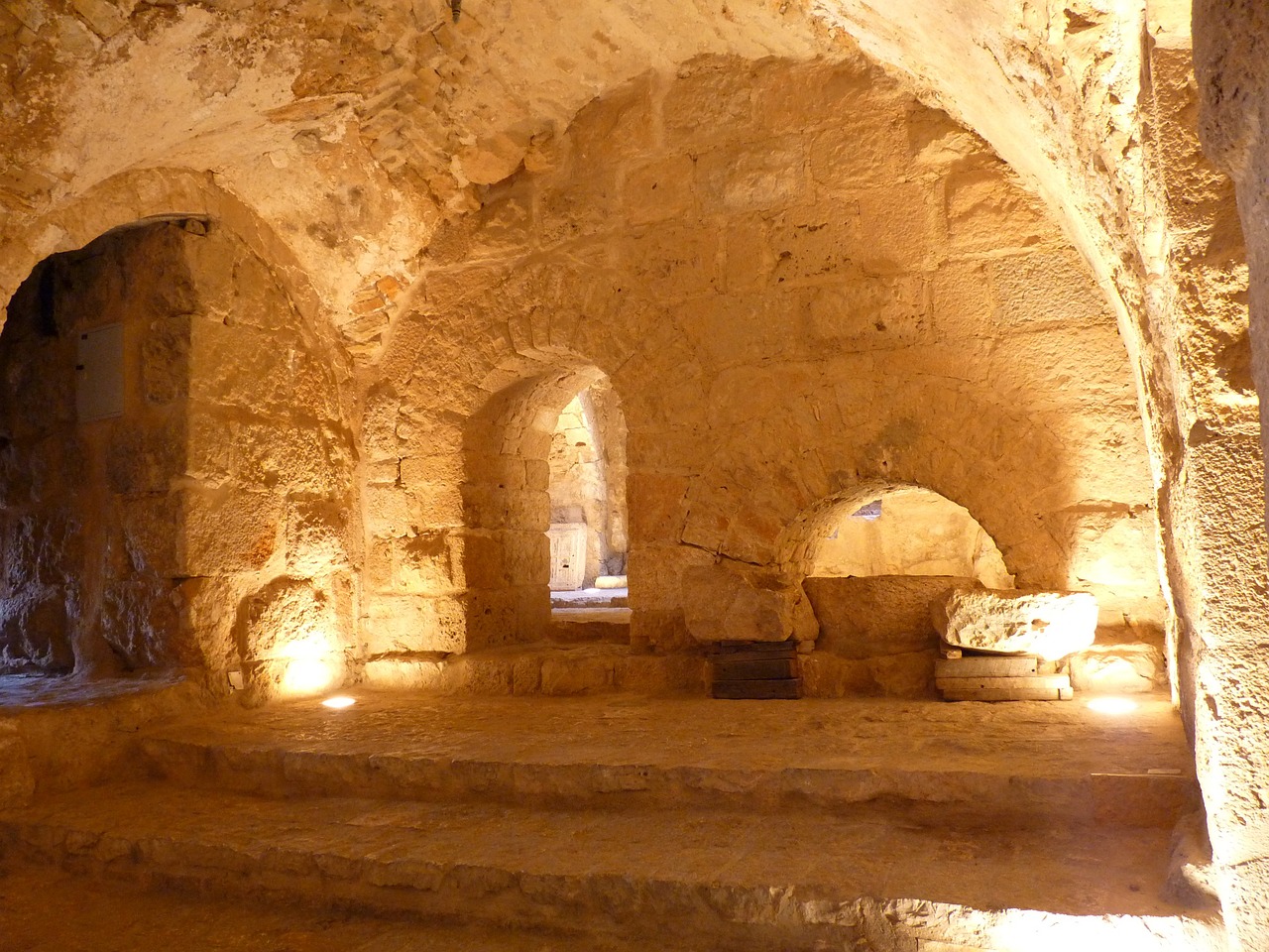 a well lit room in an old stone building, by Saul Yaffie, flickr, inside the tomb of jesus, portcullis, citadel, museum photo