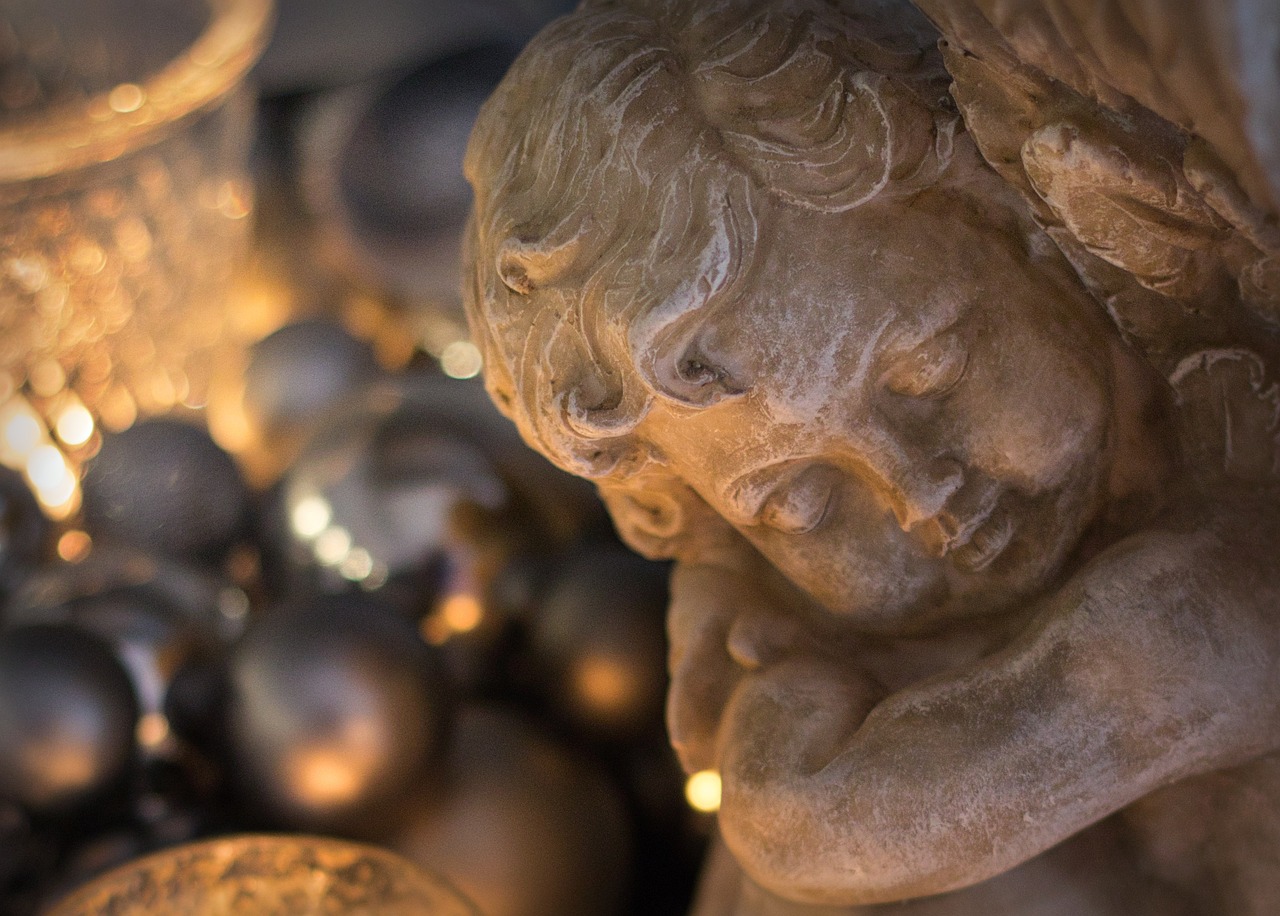 a close up of a statue with ornaments in the background, by Jan Tengnagel, soft warm lighting, angels, bashful expression, soft lighting from above