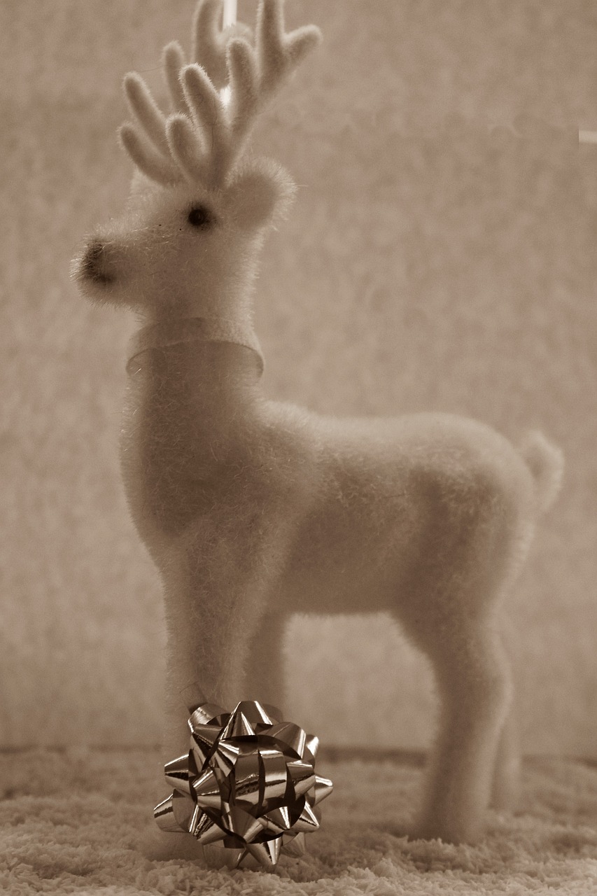 a toy deer standing next to a christmas ornament, inspired by Rudolph F. Ingerle, flickr, sepia, alpaca sculpture, felt, white horse