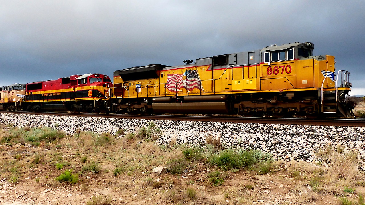 a large long train on a steel track, by Linda Sutton, flickr, yellow and red color scheme, arizona, banner, thunder