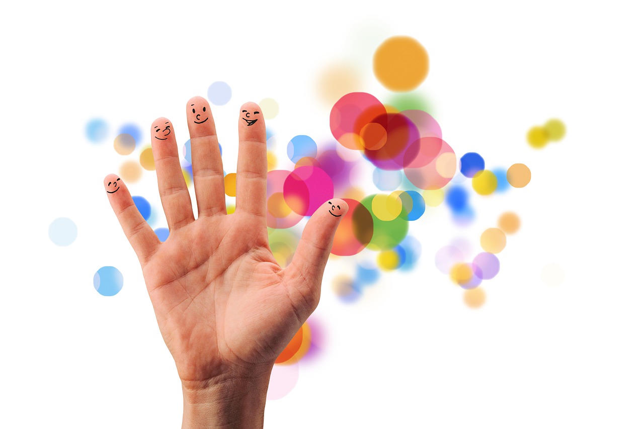 a hand with a smiley face drawn on it, a picture, by Jan Rustem, figuration libre, nice background bokeh, multicolored faces, hand with five fingers, product introduction photo