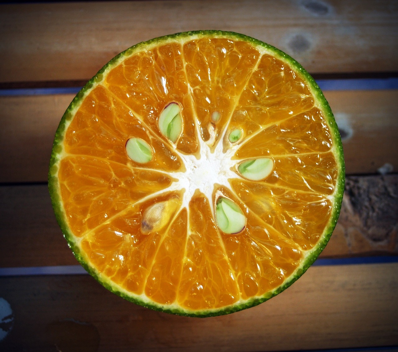 an orange sitting on top of a wooden table, by Jan Rustem, hurufiyya, underside, lime, very crisp details, citrinitas