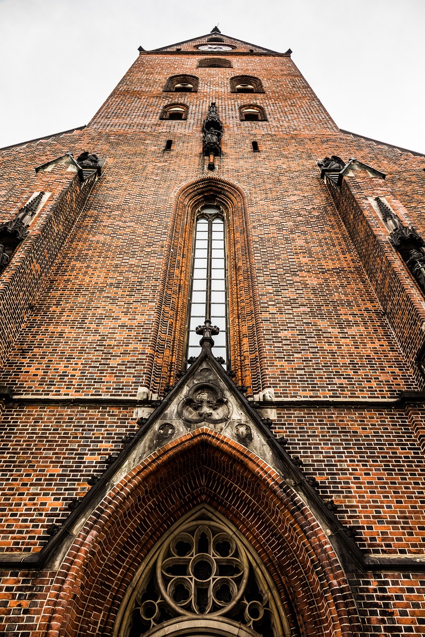 a tall brick building with a clock on the front of it, by Jacob Kainen, international gothic, gothic church background, warsaw, bottom - view, high details photo