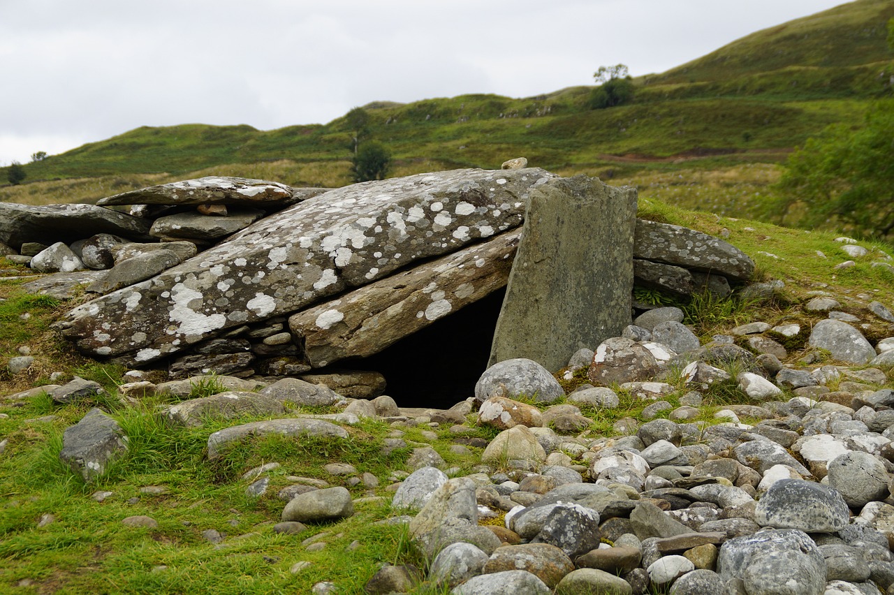 a pile of rocks sitting on top of a lush green hillside, a portrait, entrance to a dark tunnel, celtic culture, museum quality photo, containing a hidden portal