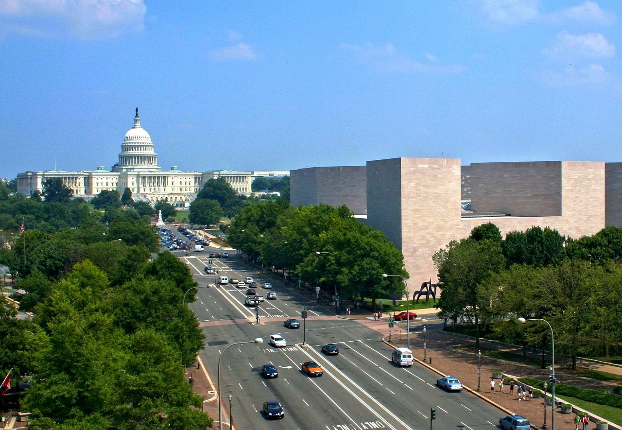 a city street filled with lots of traffic next to tall buildings, a photo, visual art, smithsonian american art museum, capitol building, overlooking, a long-shot from front