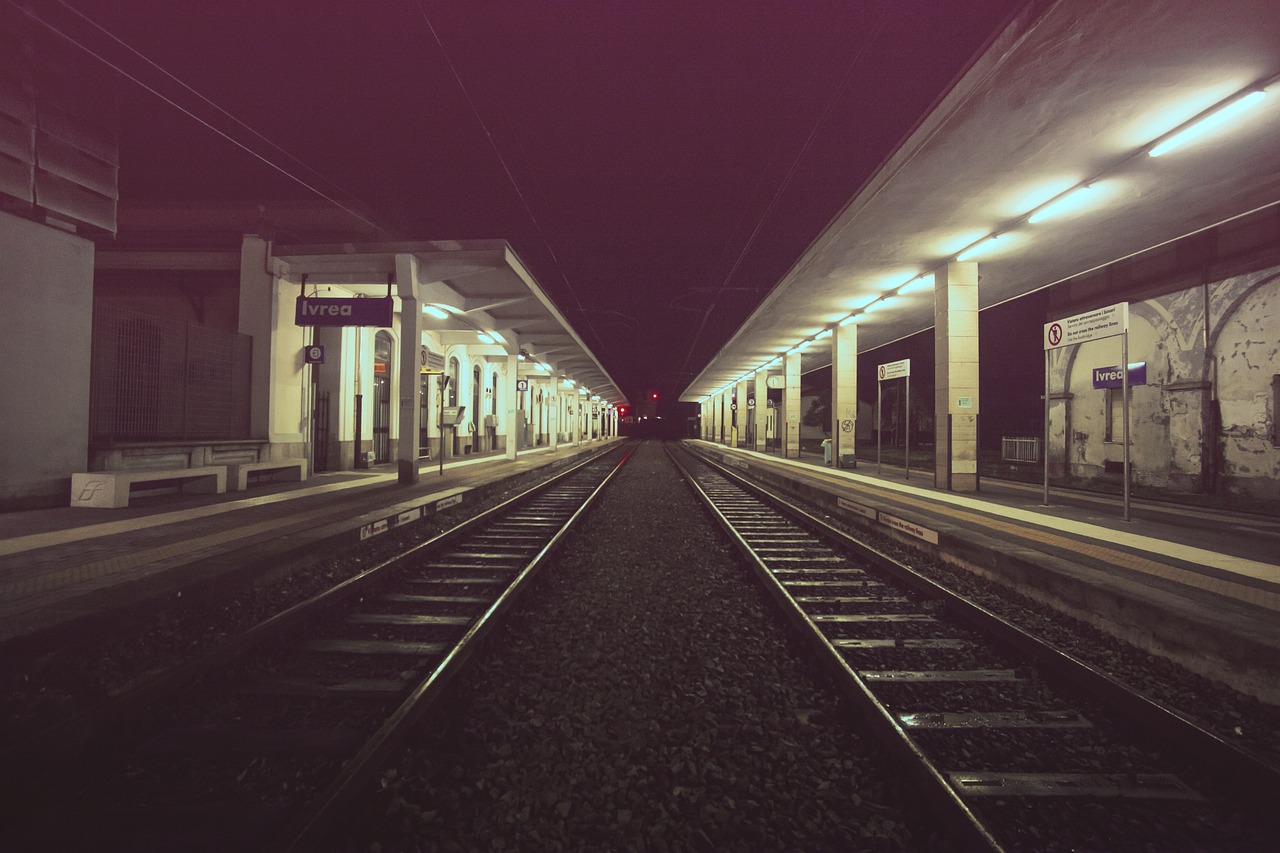 a train pulling into a train station at night, a picture, postminimalism, flickr photography, vanishing point perspective, lomography photo, lonely atmosphere