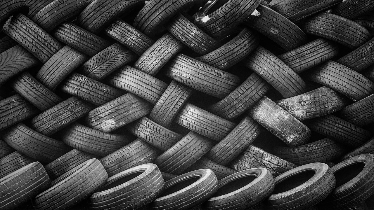 a pile of old tires stacked on top of each other, a black and white photo, by Matija Jama, pexels, fine art, vertical wallpaper, photo pinterest, grid, carbon fibers