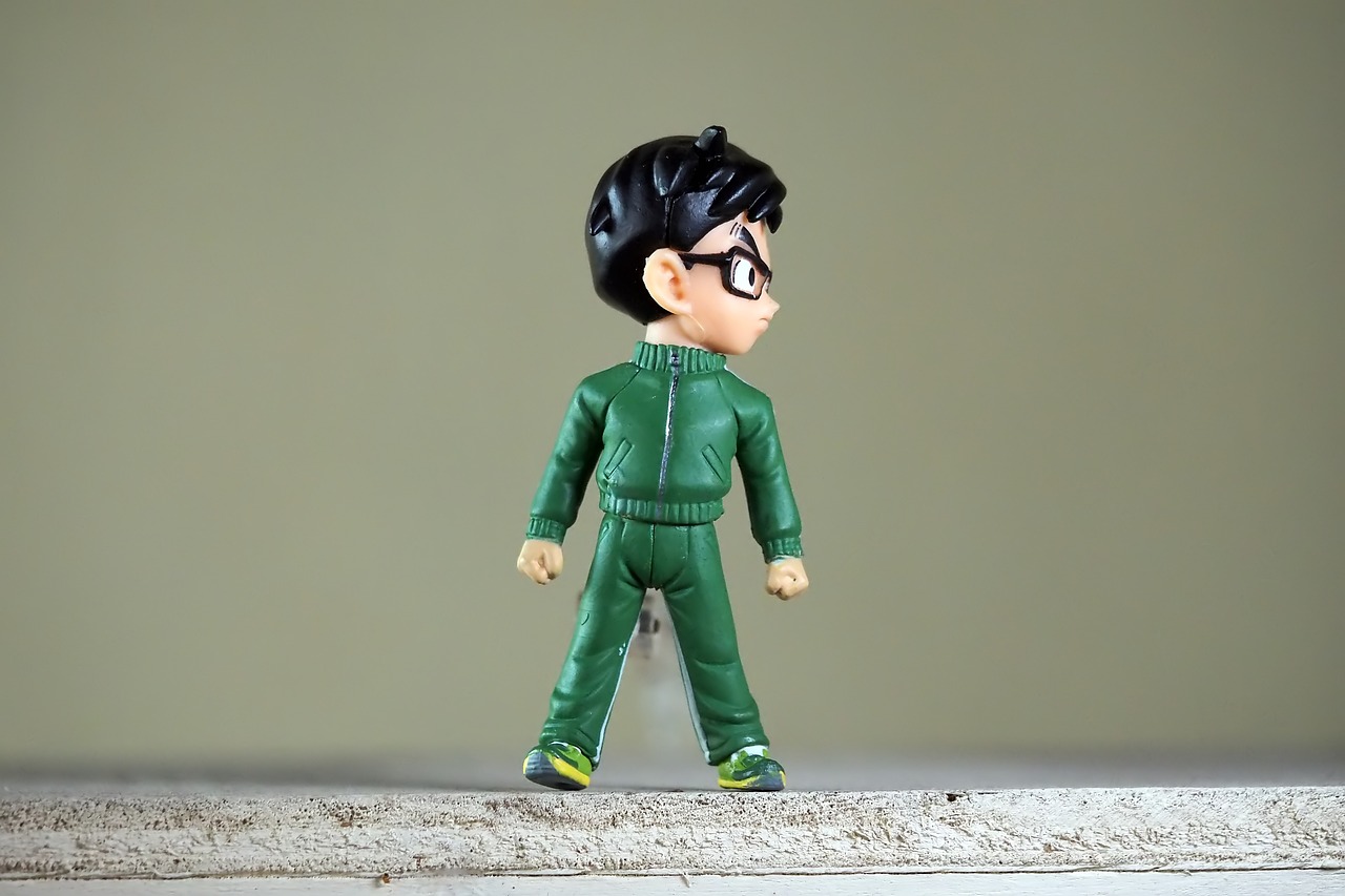 a close up of a figurine of a person on a ledge, inspired by Kinichiro Ishikawa, danny phantom, wearing a track suit, pvc figurine, john egbert