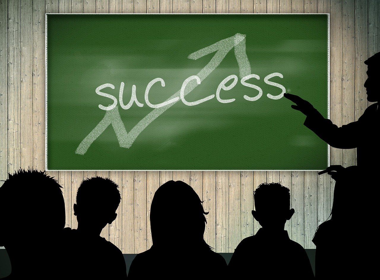 a group of people standing in front of a chalk board, by Kurt Roesch, pixabay, success, photo of a classroom, silhouette!!!, saying