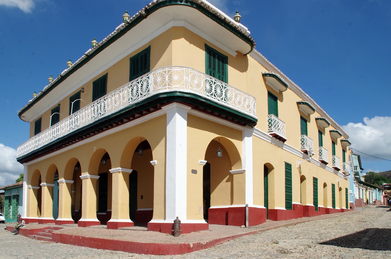 a large yellow building sitting on the side of a road, inspired by Ceferí Olivé, colonial style, olive green and venetian red, exterior view, don ramon