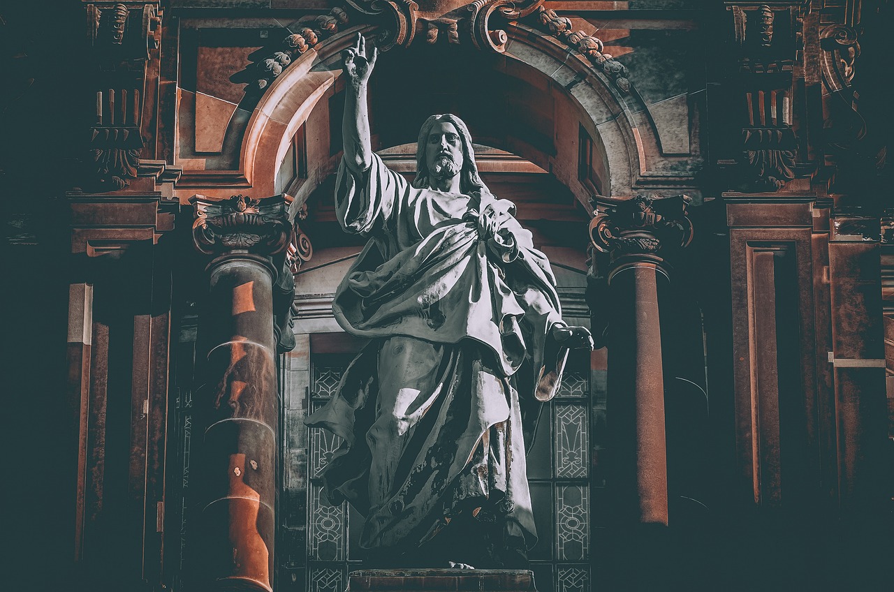 a statue of jesus in front of a building, by Matija Jama, pexels, baroque, on a dark background, waving, in an ancient altar, photo pinterest