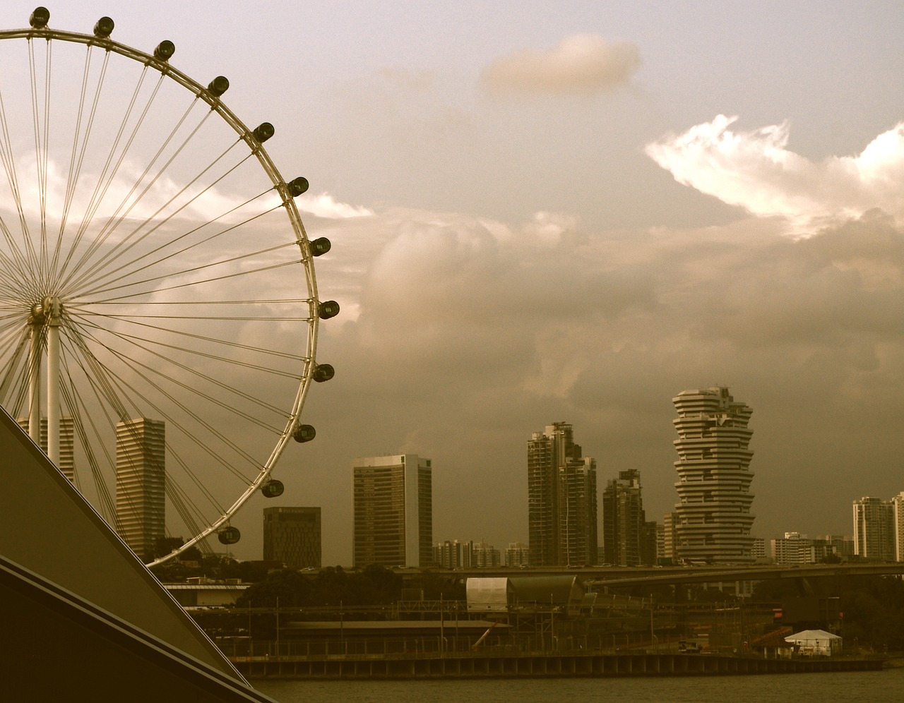 a ferris wheel in front of a city skyline, inspired by Joze Ciuha, flickr, hurufiyya, singapore esplanade, very hazy, big eye, clouds around