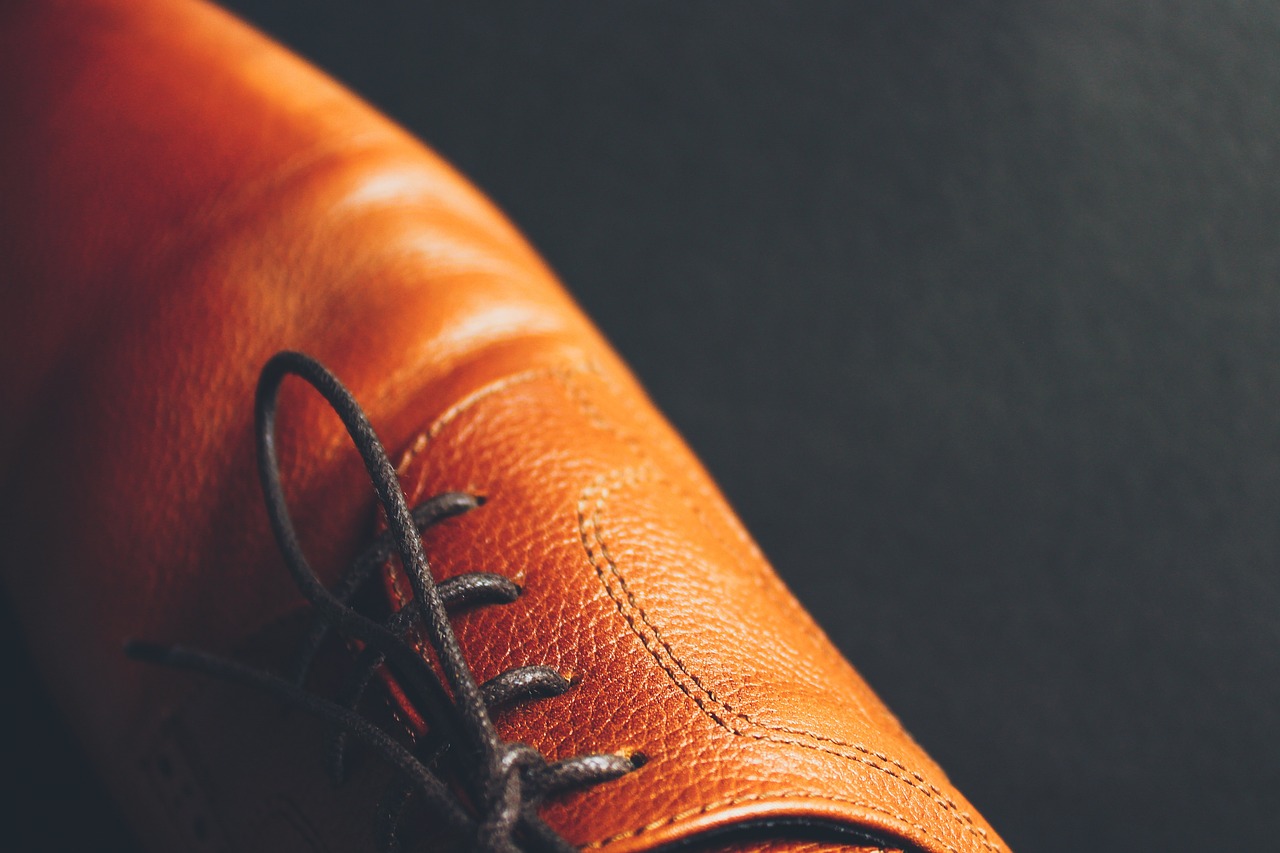 a pair of brown shoes with laces on them, a macro photograph, dark orange, skin grain detail, thumbnail, leather interior