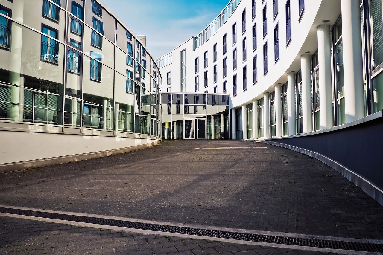 a couple of buildings that are next to each other, a photo, by Kristian Zahrtmann, pixabay, courtyard walkway, ground-level view, research complex, slightly sunny