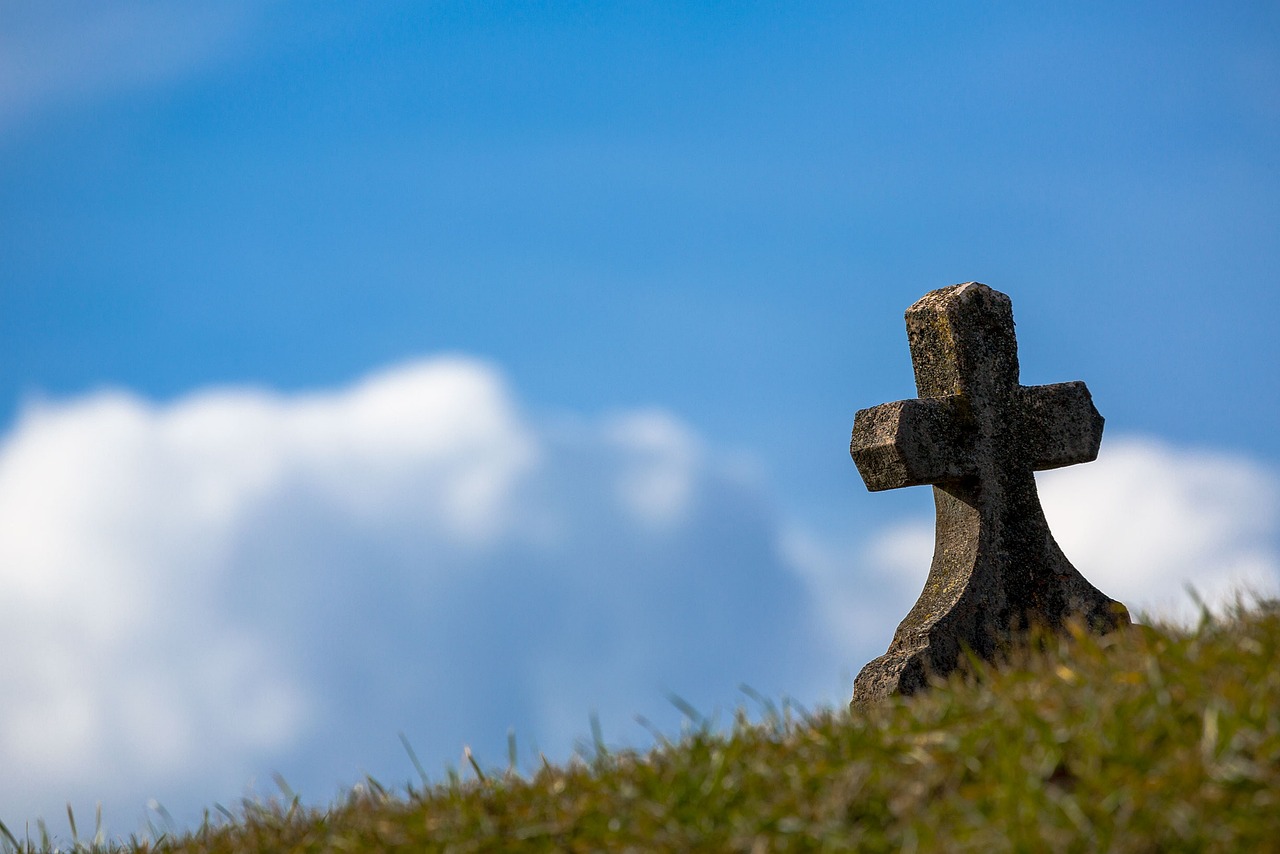 a stone cross sitting on top of a grass covered hill, pixabay, walk in a funeral procession, low - angle, half image, dead