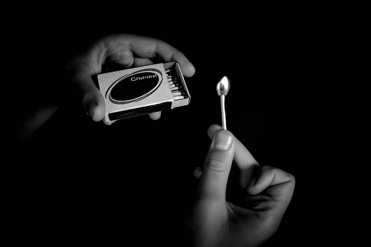 a person holding a matchstick in their hand, a black and white photo, pixabay, contracept, charon, small gadget, uplit