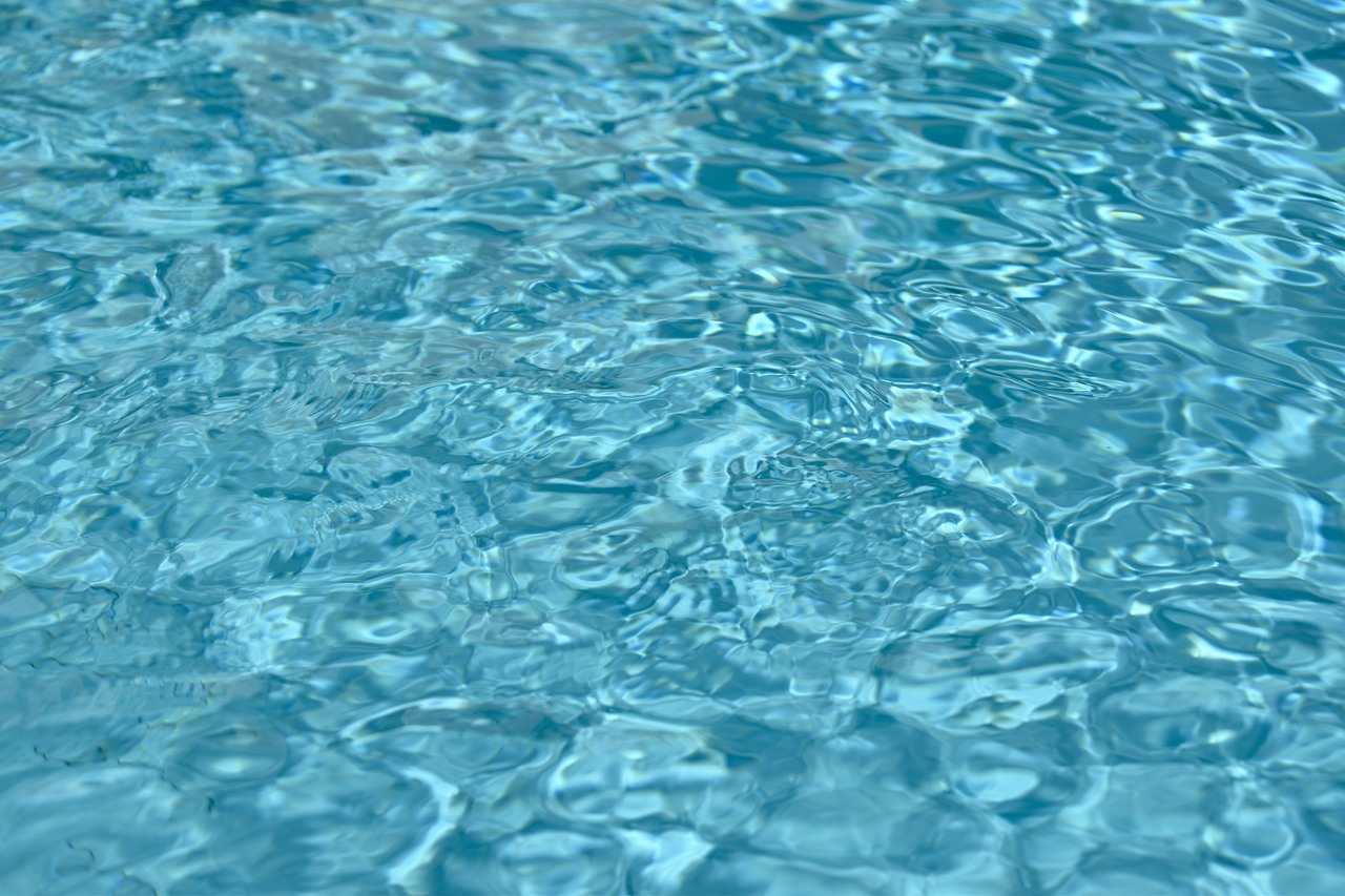 a close up of a pool with a frisbee in it, a digital rendering, photorealism, soft blue texture, high detail photo
