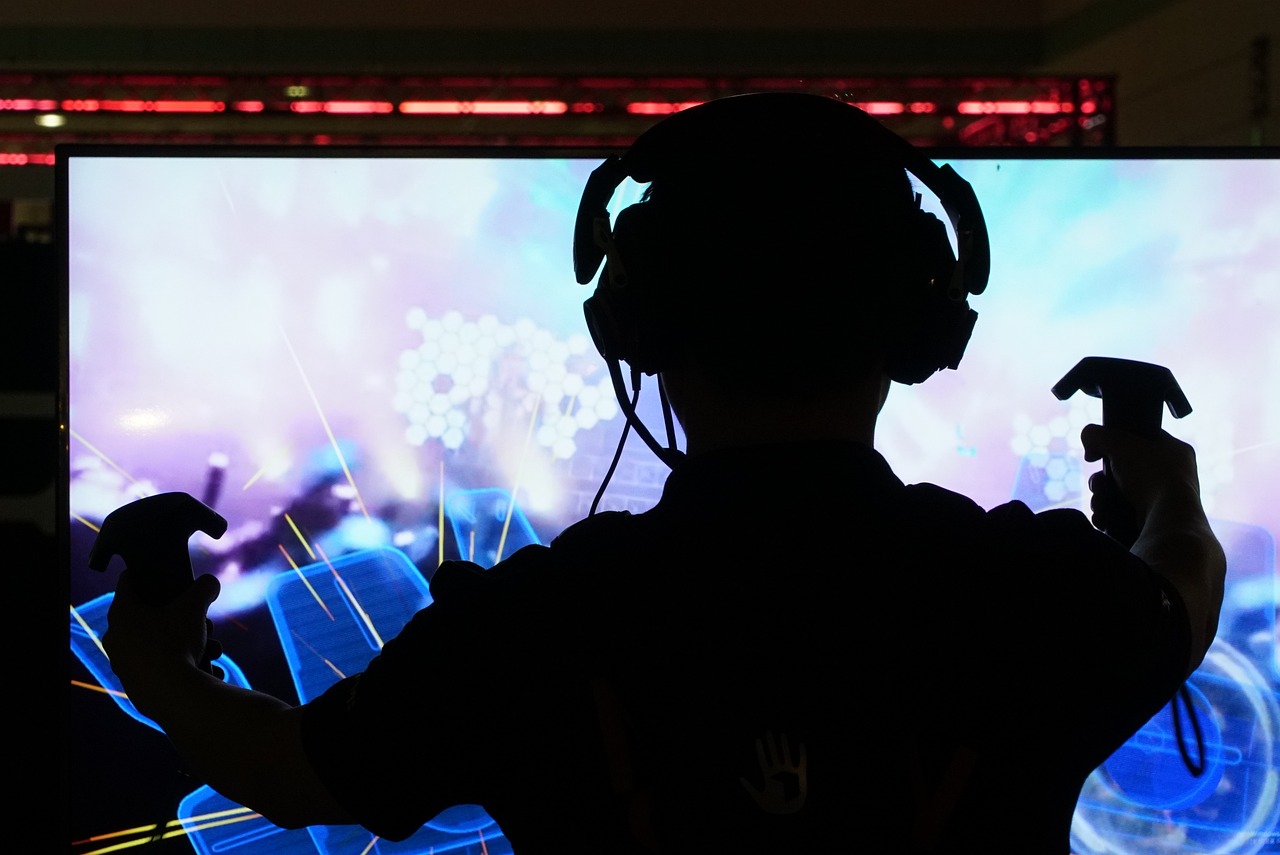 a person holding a video game controller in front of a tv, interactive art, with head phones, shot from below, banner, afp