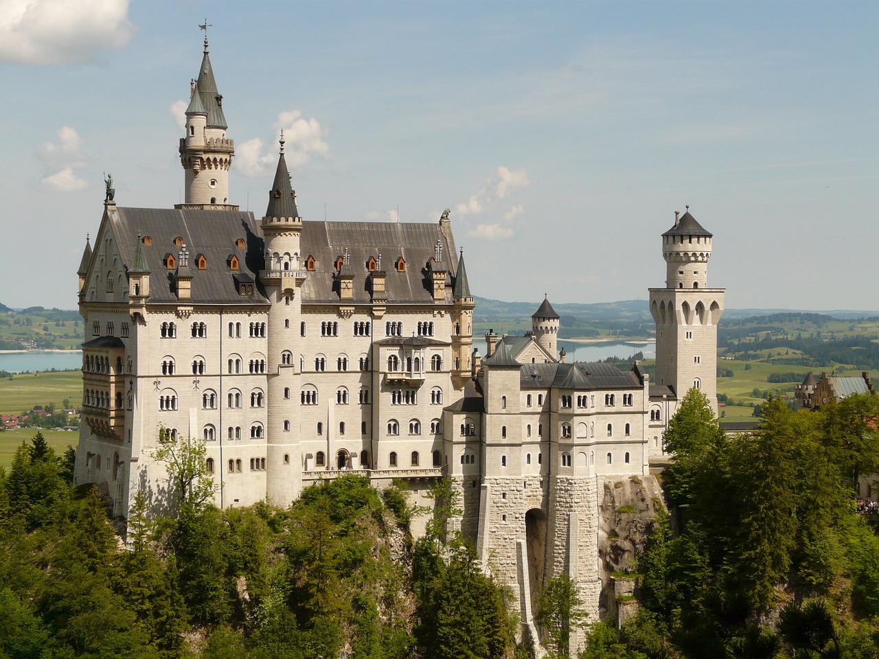 a castle sitting on top of a lush green hillside, trending on pixabay, art nouveau, munich, white marble buildings, immaculately detailed, elegant walkways between towers