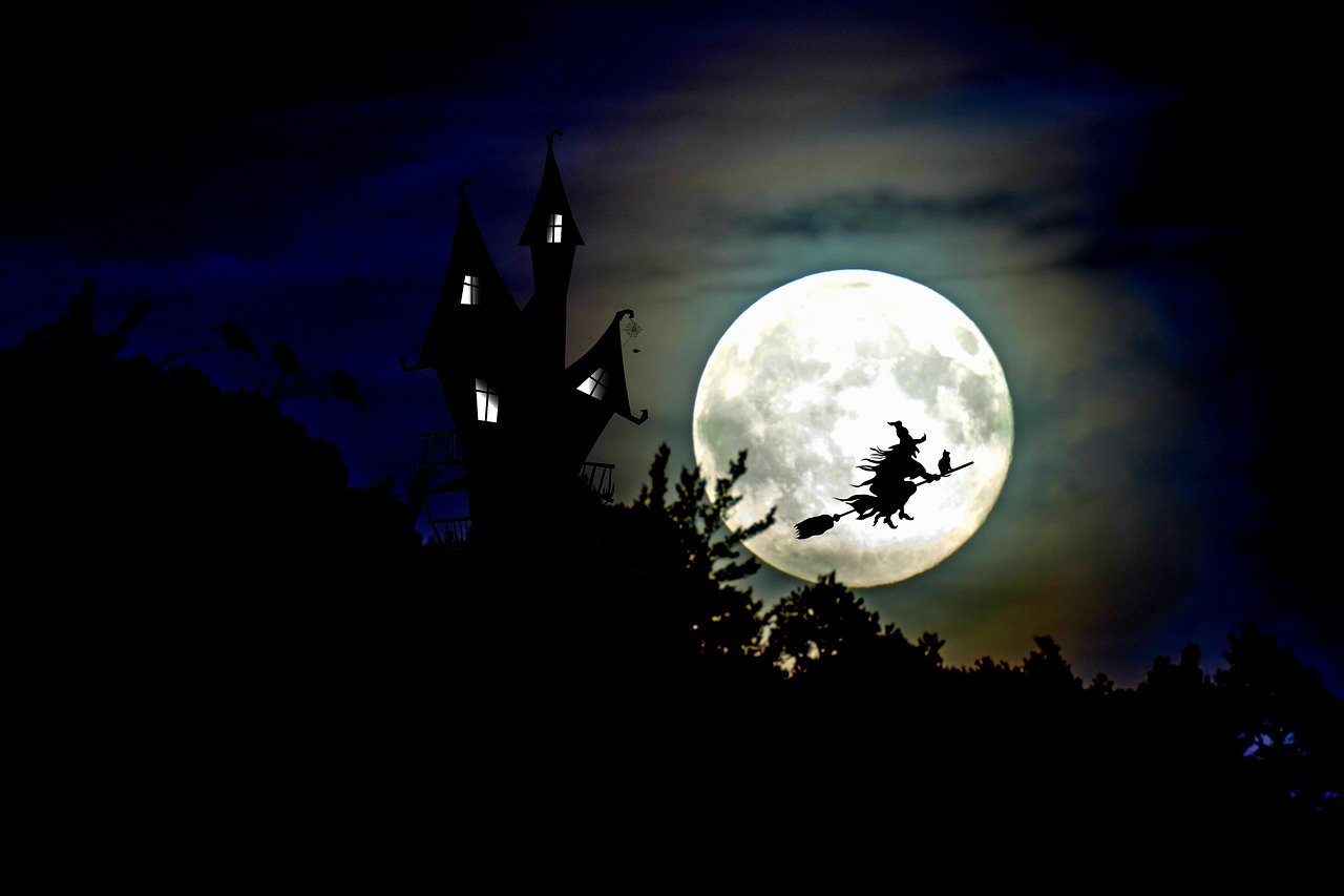 the moon is shown above a spooked silhouette of a witch with her broom