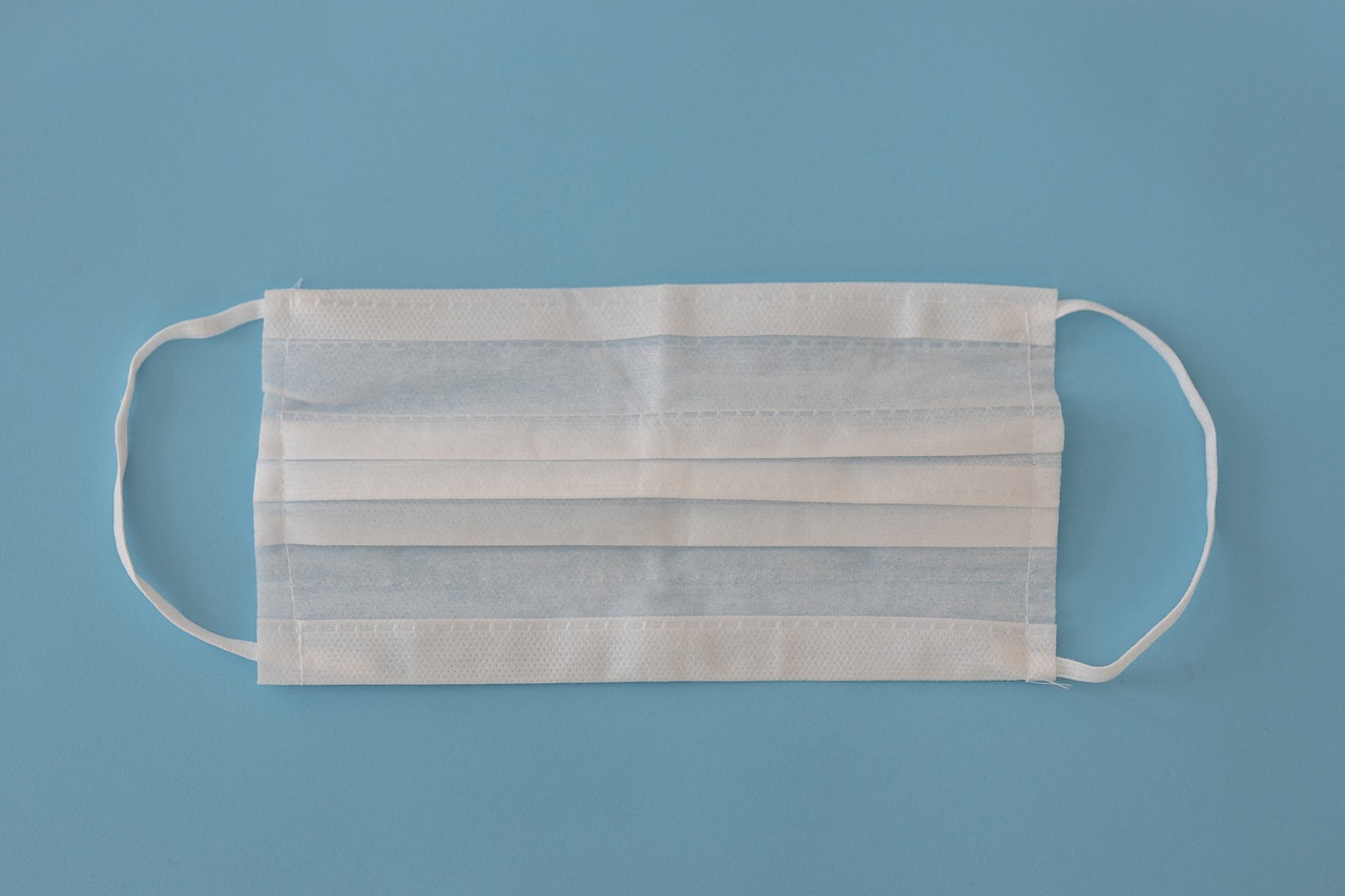 a white face mask with four rows of white string on the bottom and side