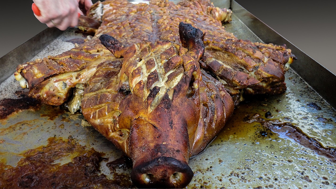 a meat roaster with a large piece of meat on the grill