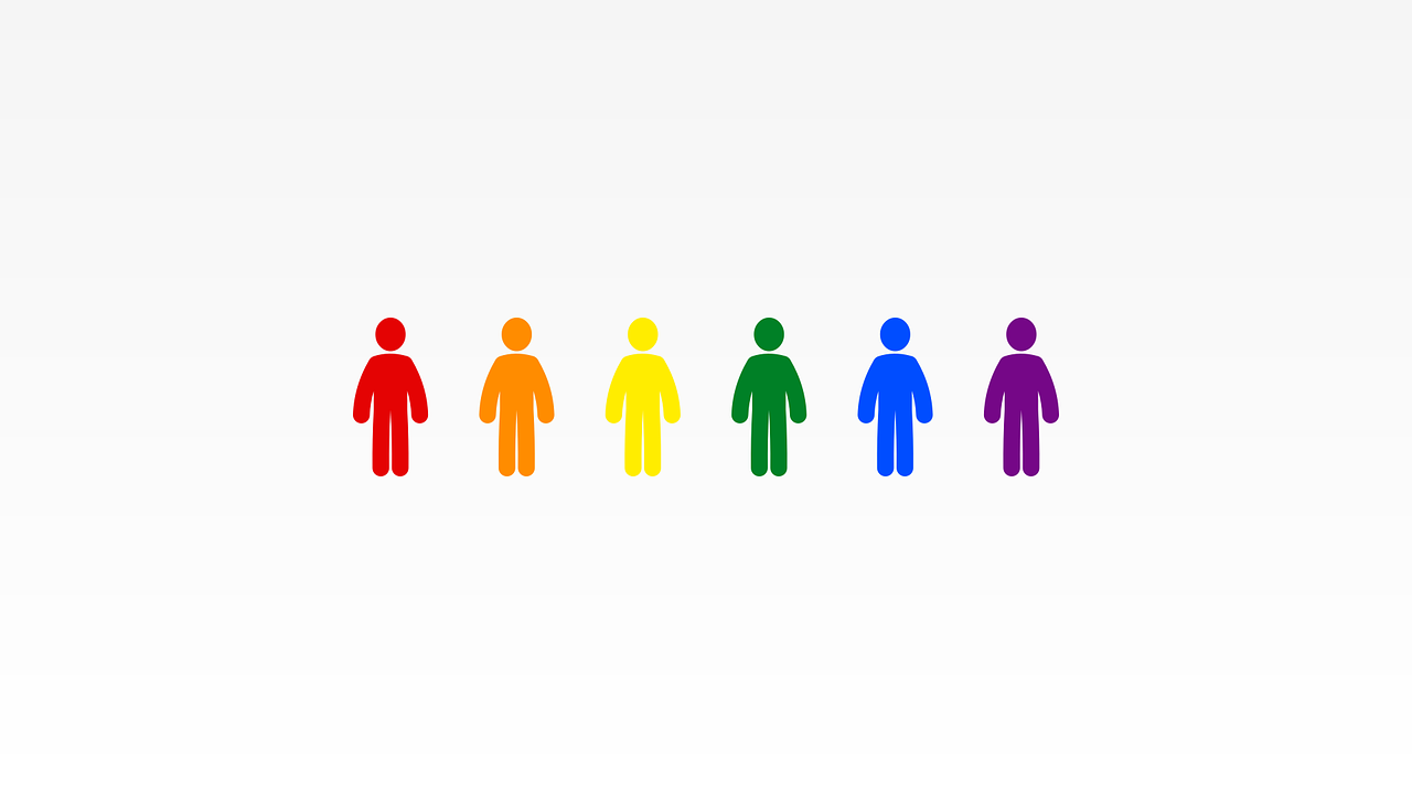 a group of people are standing next to each other with rainbow colors