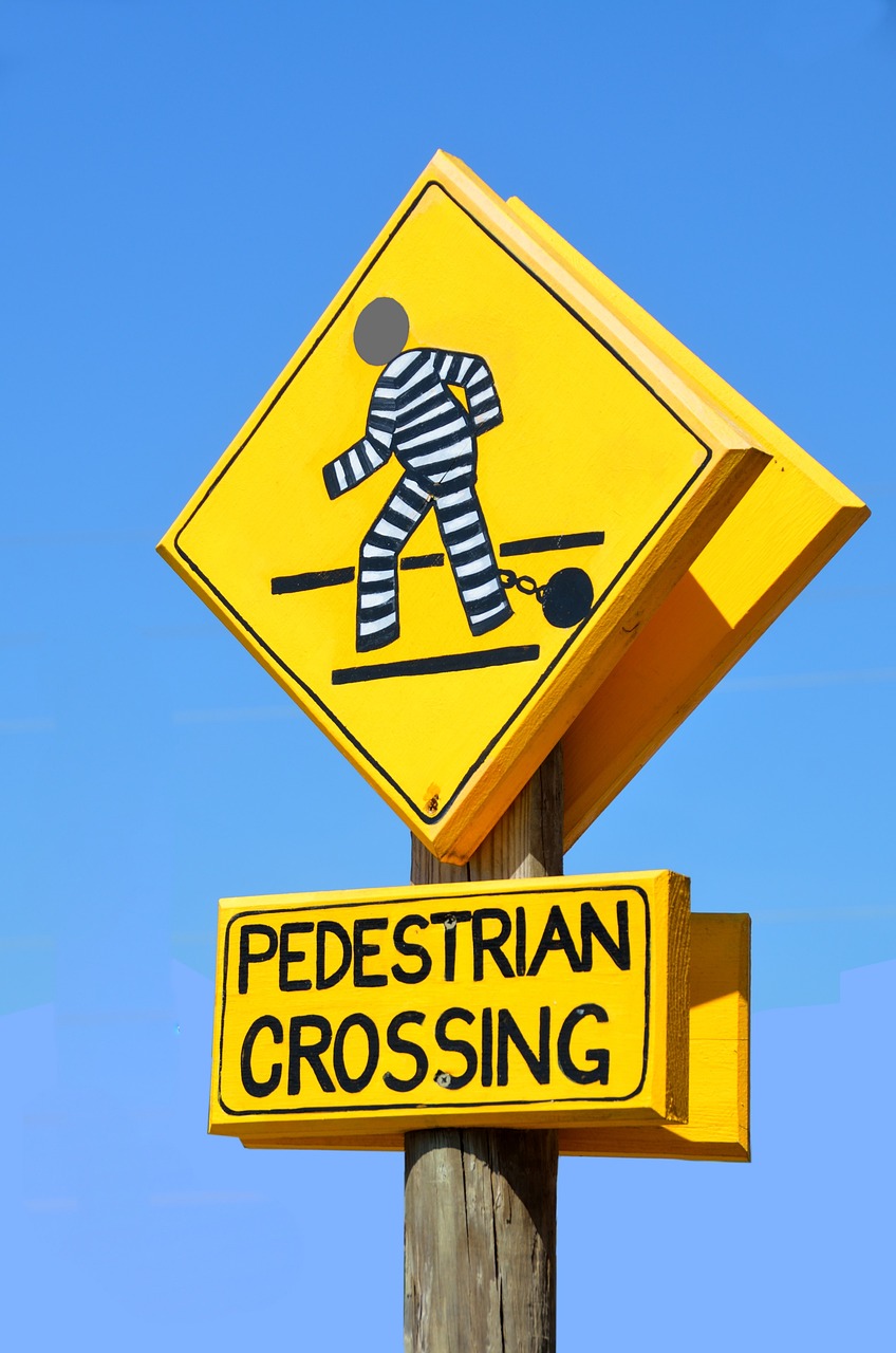 a pedestrian crossing sign on a wooden pole