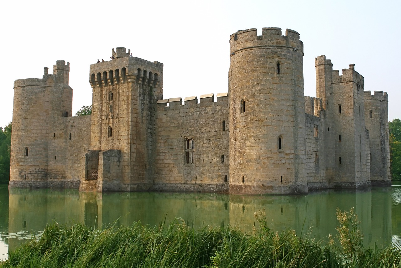 a large brick castle with a pond in the foreground