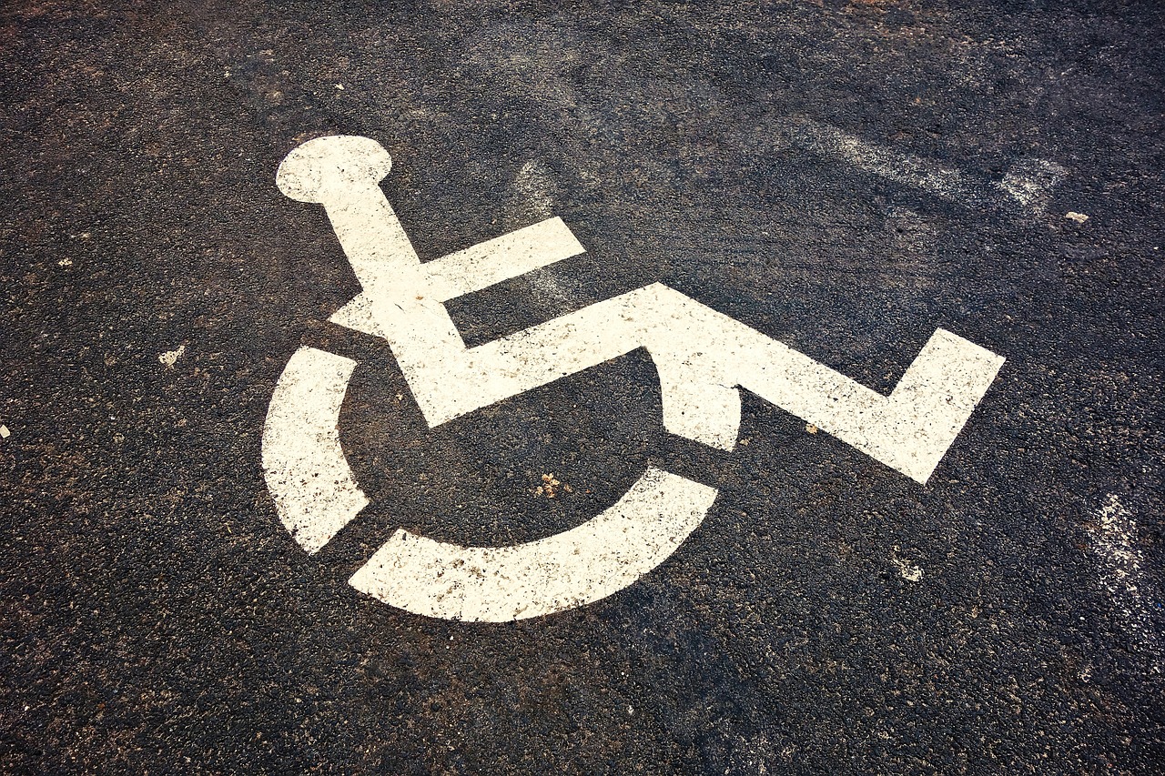 a handicapped sign is drawn on an asphalt surface