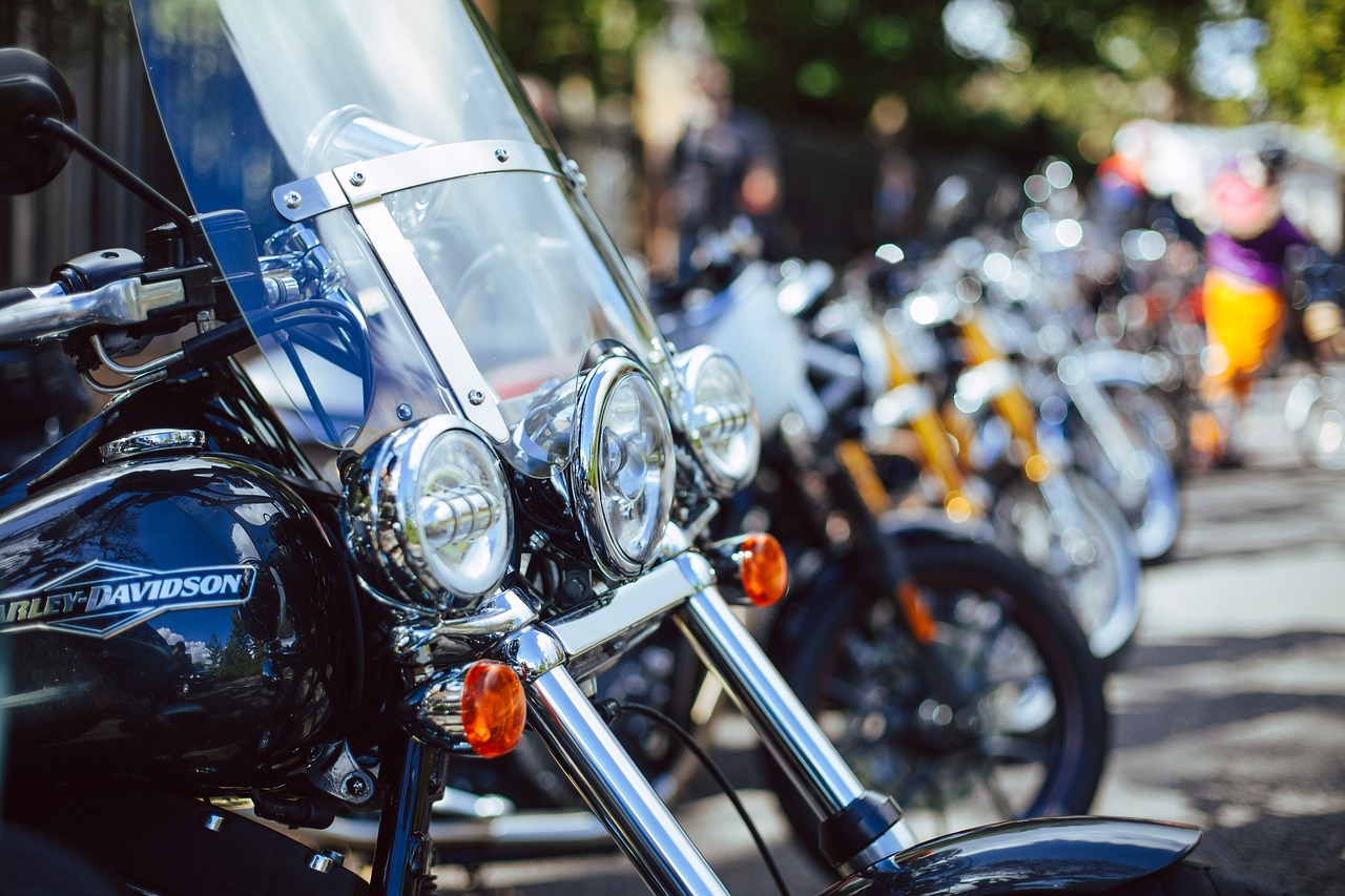 a line of motorcycles parked close together in a parking lot