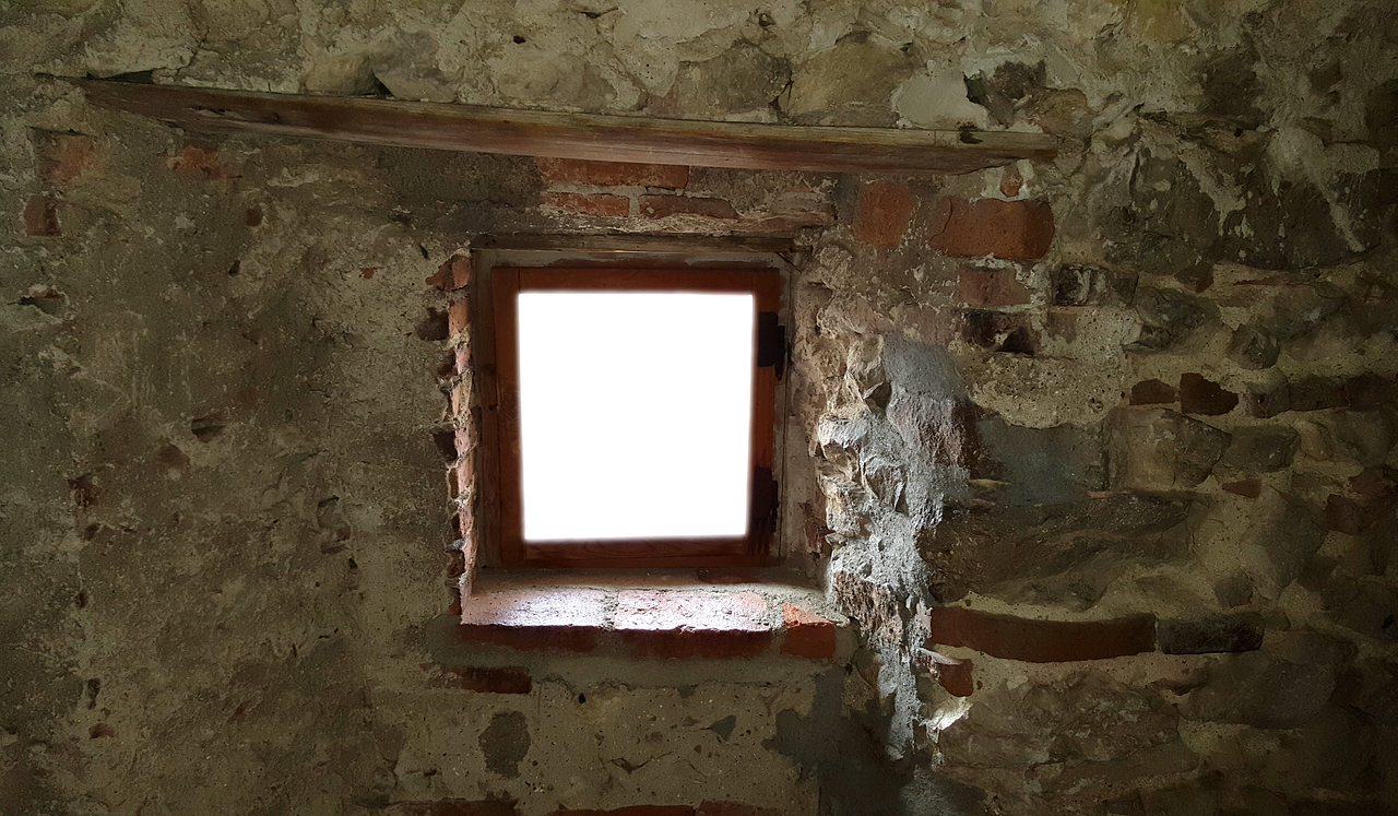 a window is seen in an old brick building
