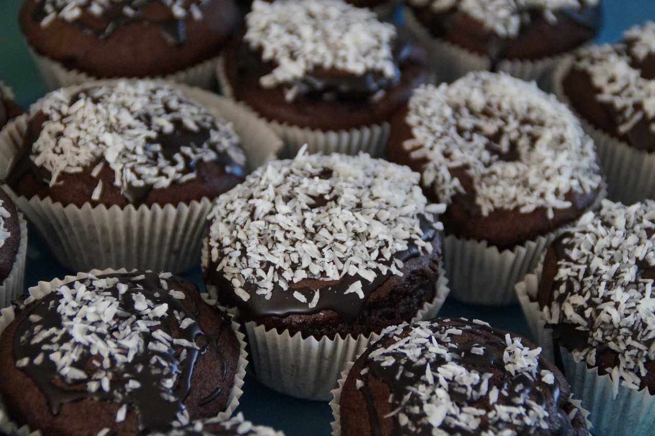 a group of chocolate cupcakes covered in white and sprinkles