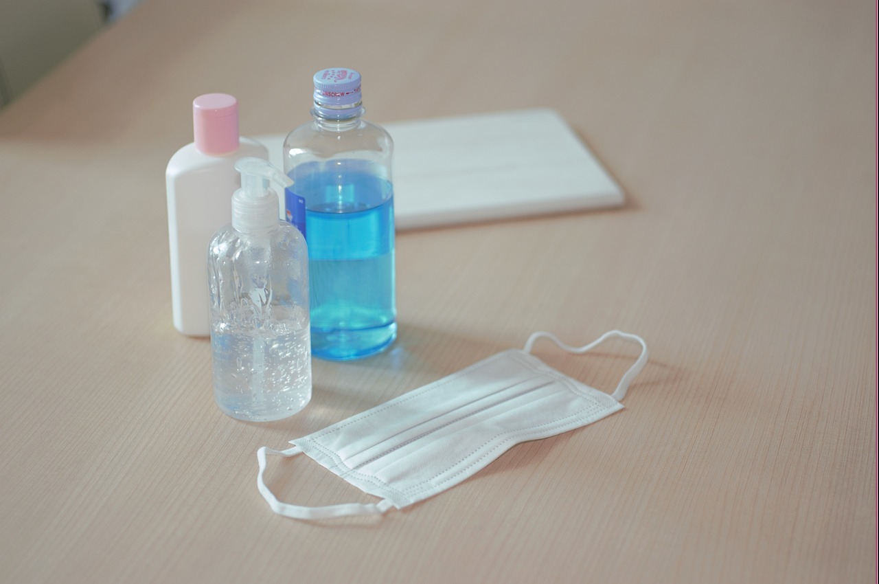 an unkempt bag of blue and a bottle of mouthwash and a face mask are sitting on a table