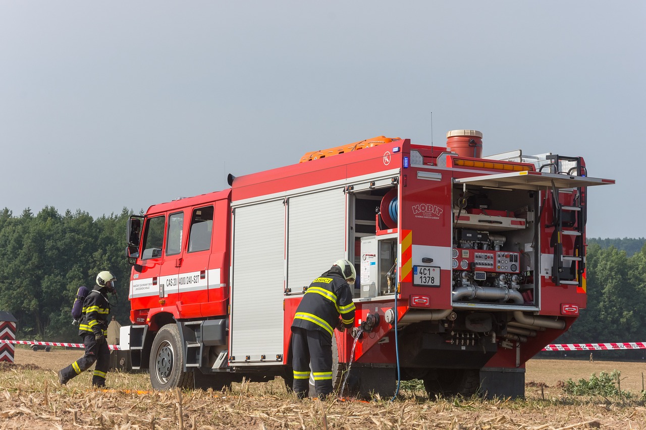 three firemen are working on the back of a fire truck